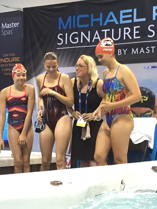 Heidi posa para una foto con nadadores en las pruebas de natación de Omaha