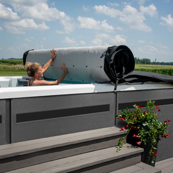 Mujer retirando la cubierta Axis desde el interior de un spa de natación.